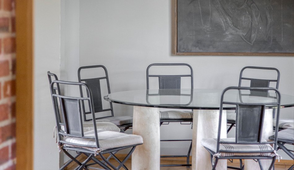 La table à manger avec son plateau de verre et les 8 chaises