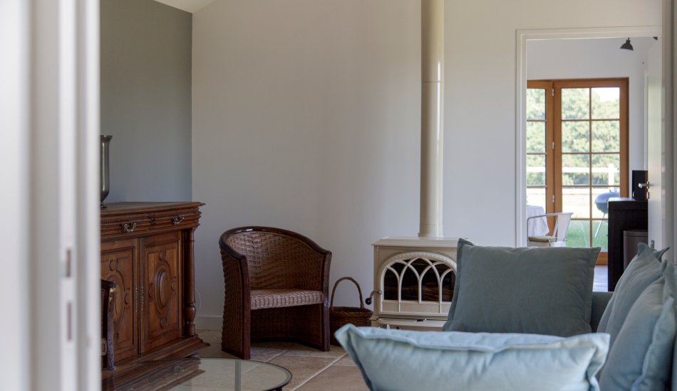 Salon avec canapé convertible, fauteuil et poêle à bois